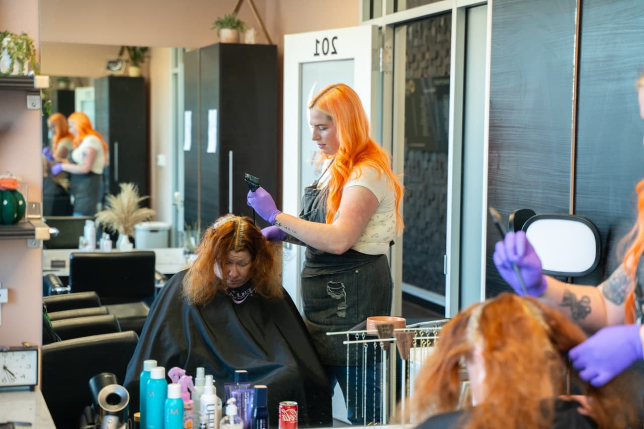 Stylists working with clients on the shared floor of a traditional salon
