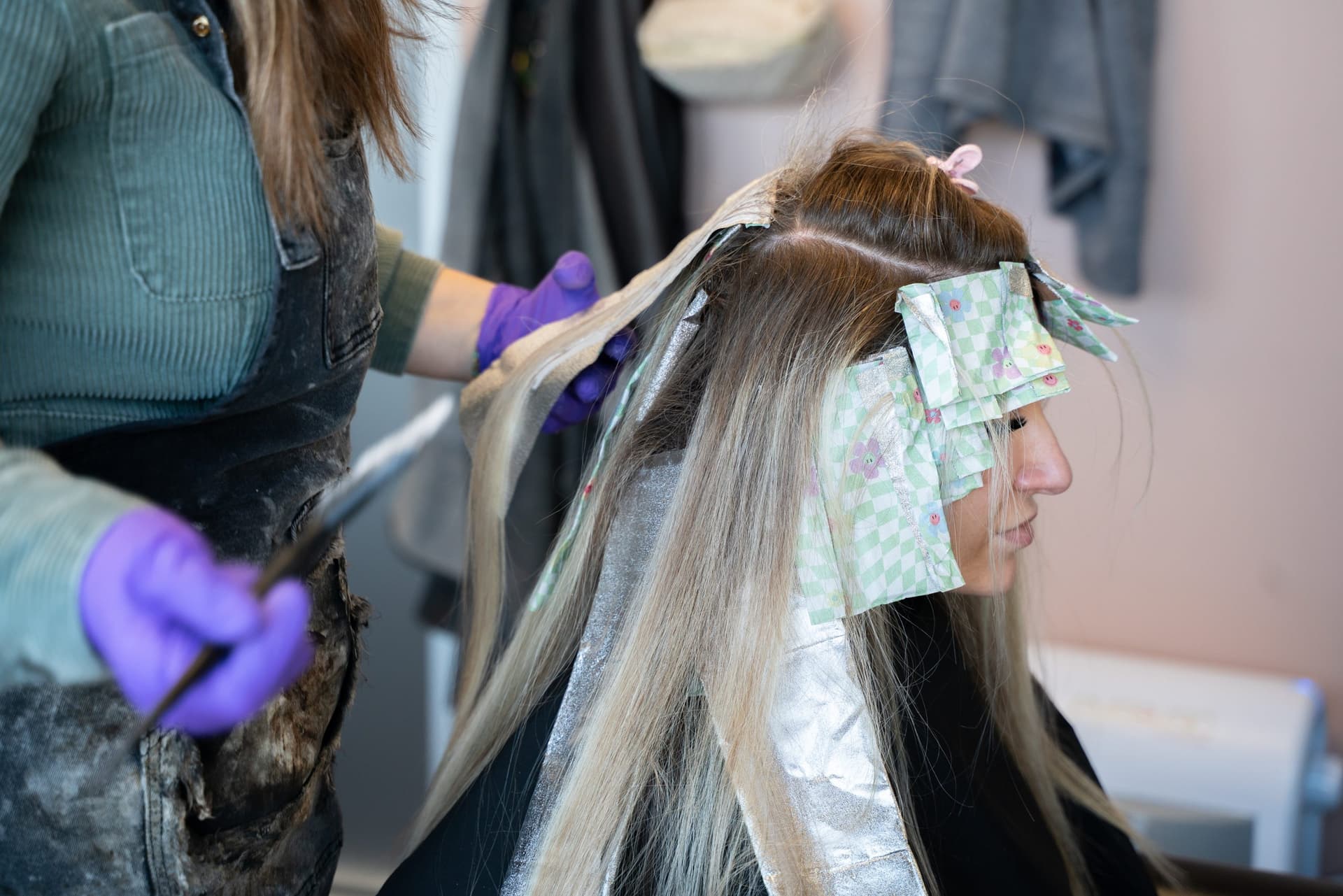 Stylist applying foil highlights in her salon suite