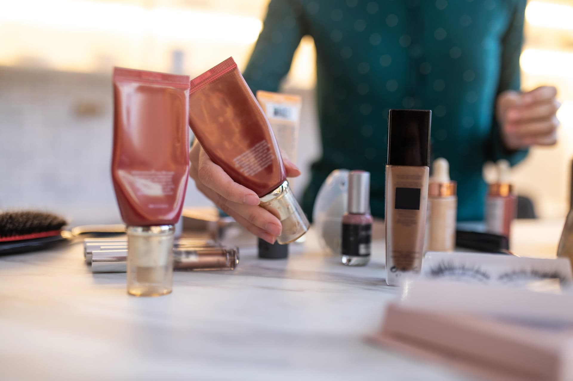 Stylist arranging retail product display in a Florence salon suite at The Hive Salon Studios.
