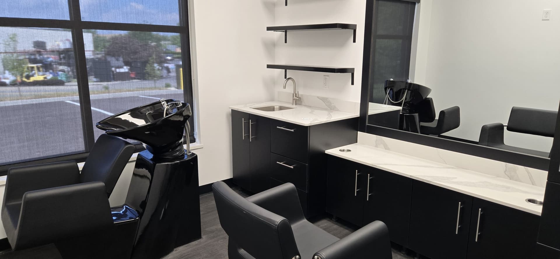 Bright salon suite with window view, shampoo bowl and styling station at The Hive